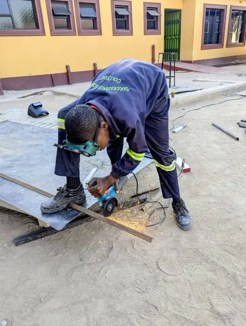 A learner using protective equipment during metalwork